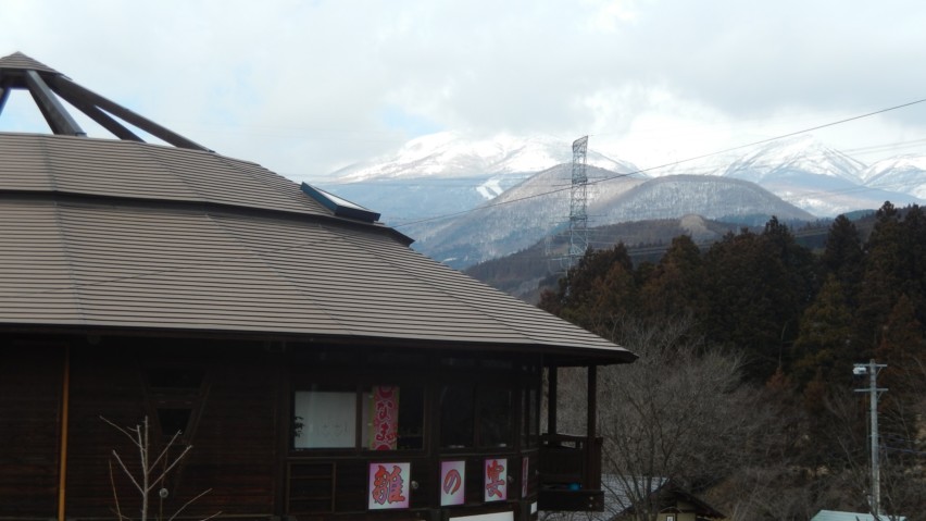 Kokeshi Museum with a beautiful view of the mountains behind it.