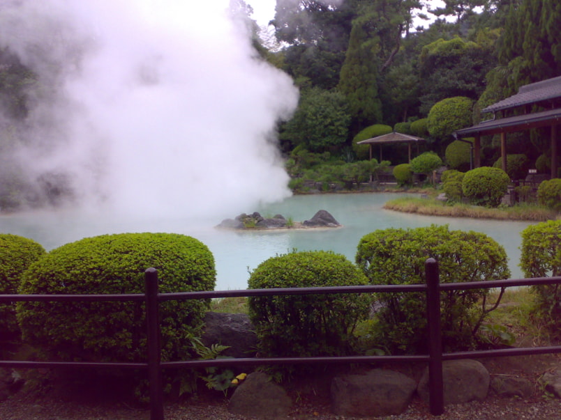 A steaming hot spring in the middle of a green landscaped garden