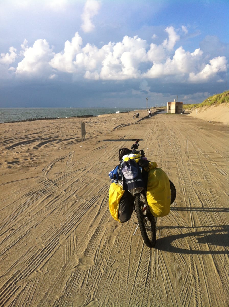 mountain bike with saddle bags parked on a beach