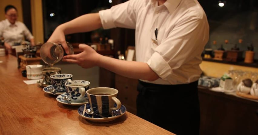 A waiter prepares coffee for customers at Mori no Tokee coffeeshop, Ningle Terrace, Furano, Hokkaido, Japan