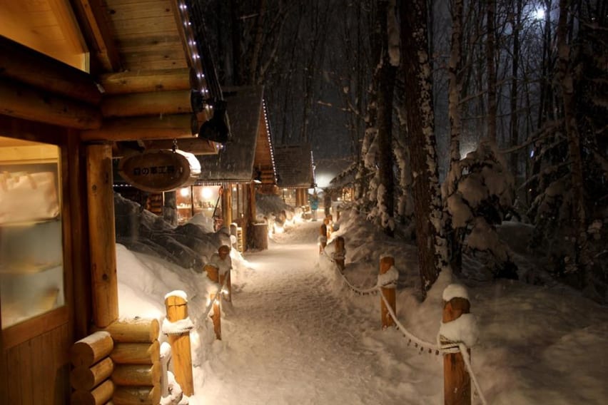 Line of illuminated log cabins at Ningle Terrace, Furano, Hokkaido, Japan