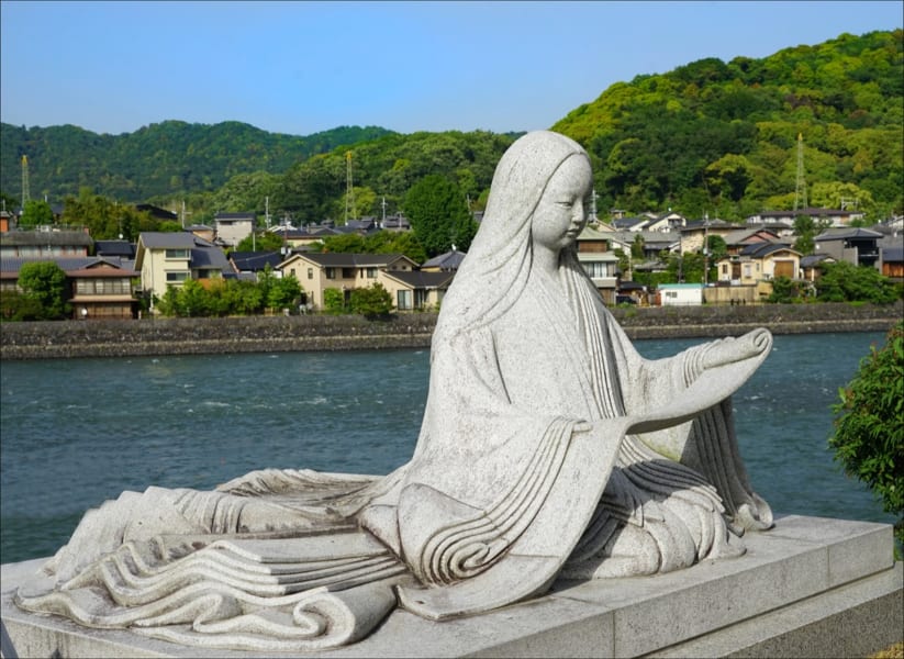 Statue of Murasaki Shikibu in front of the river