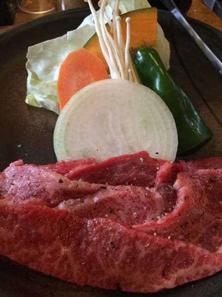 raw Oki beef and raw vegetables on a grill