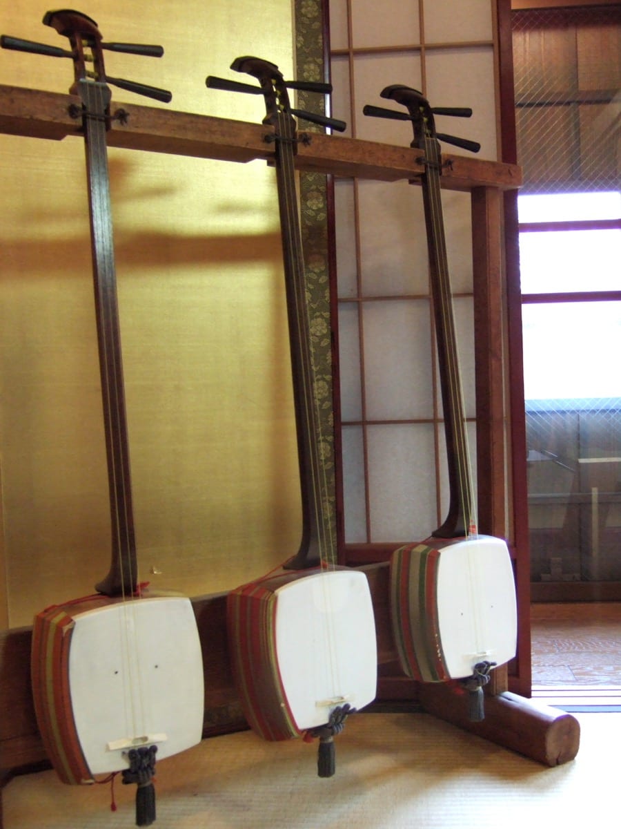 Shamisen sitting upright in a stand